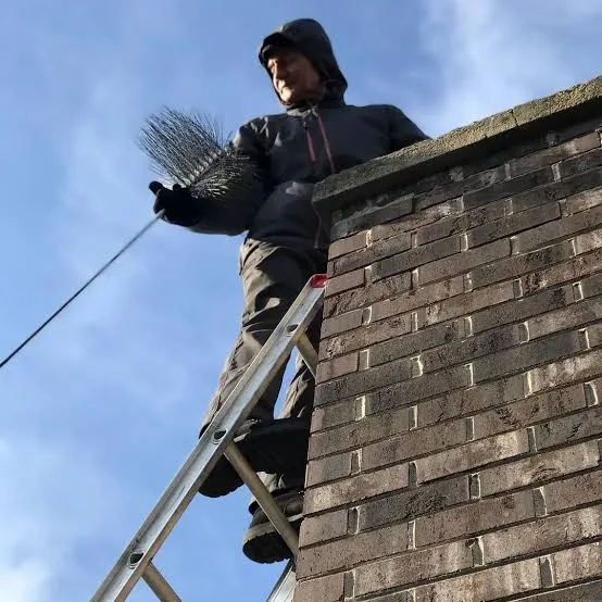 Chimney professional inspecting a residential roofline
